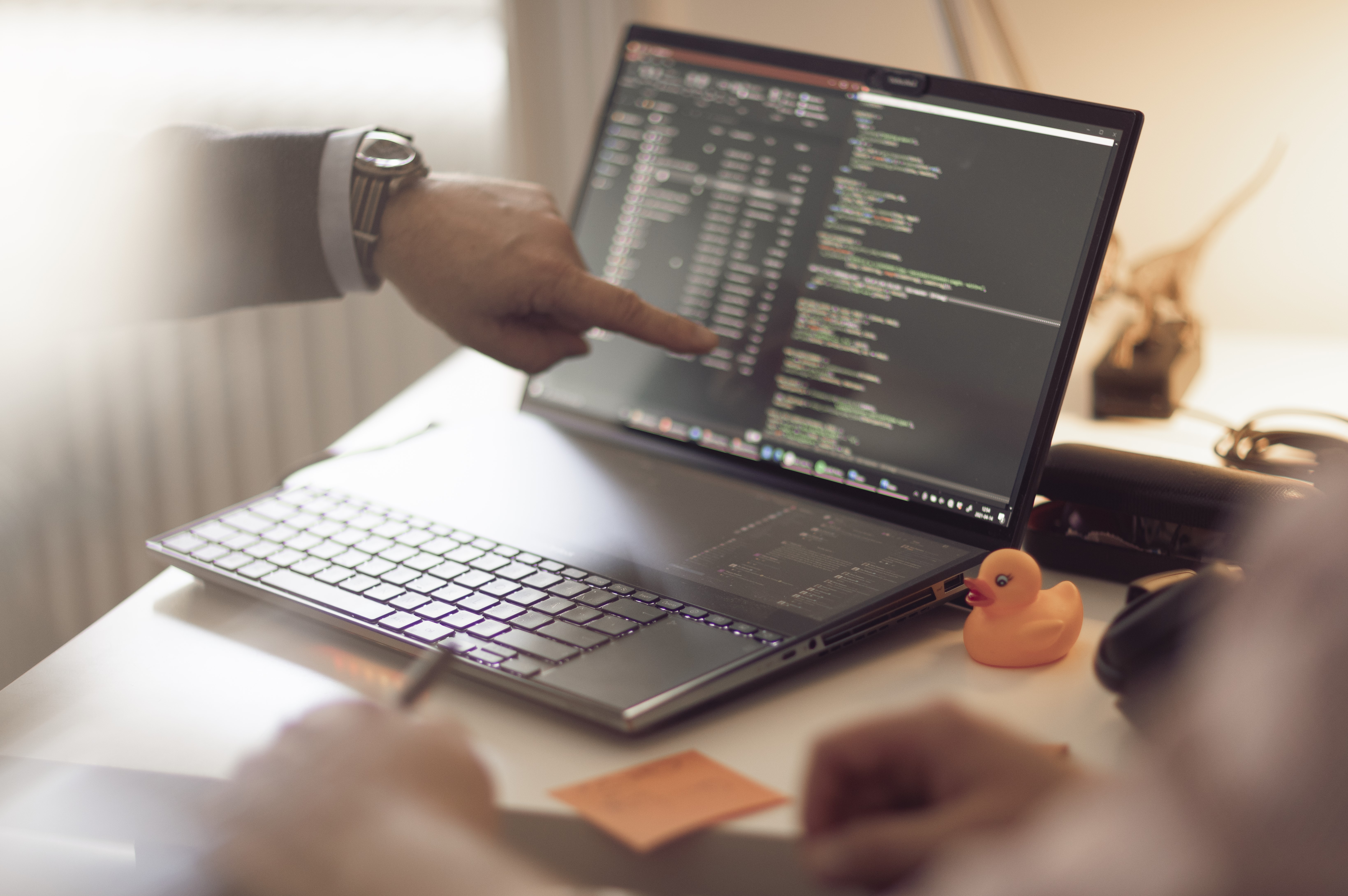 Me pointing at a computer with a rubber duck on the side.